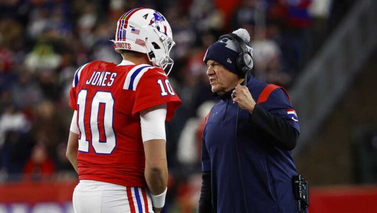 New England Patriots head coach Bill Belichick talks with quarterback Mac Jones during an NFL football game against the Buffalo Bills at Gillette Stadium, Thursday, Dec. 1, 2022 in Foxborough, Mass. (Winslow Townson/AP Images for Panini) SOURCE: Winslow Townson